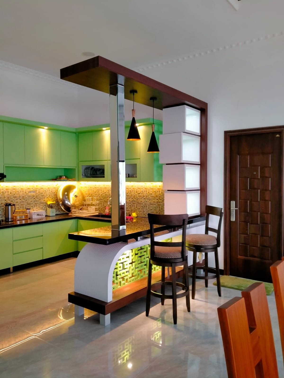 Kabinet atas dan bawah dapur berwarna hijau muda dengan lampu di bawah kabinet.