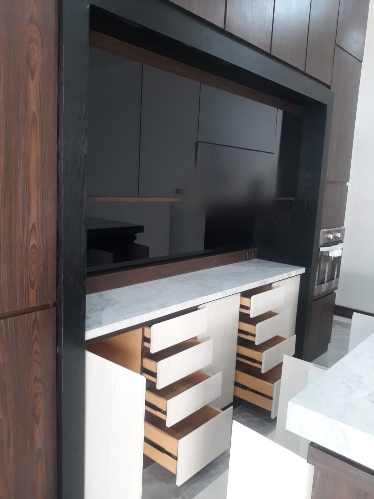 Detail laci dapur yang terbuka memperlihatkan rel laci dan meja batu di atasnya.
