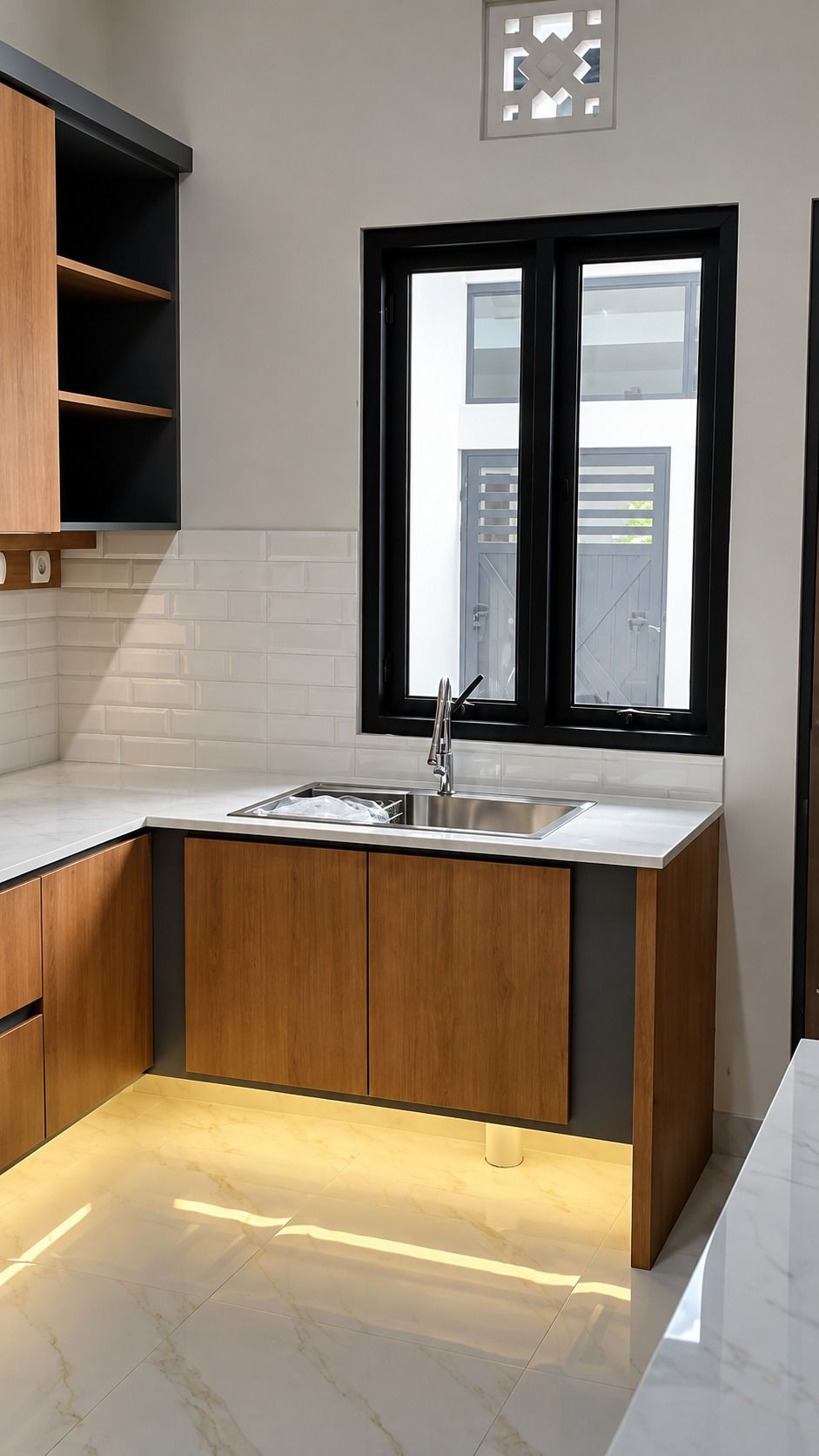 Dapur bentuk L dengan kabinet bawah motif kayu, sink di bawah jendela, dan cahaya hangat di bawah kabinet.