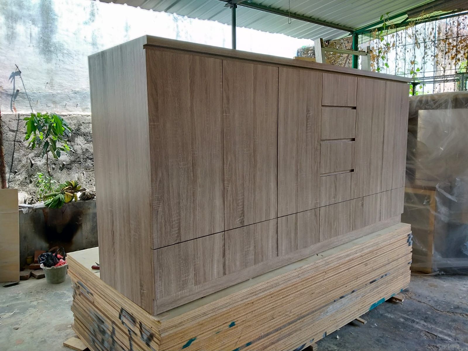 Sisi lain lemari penyimpanan memperlihatkan susunan laci dan panel samping.