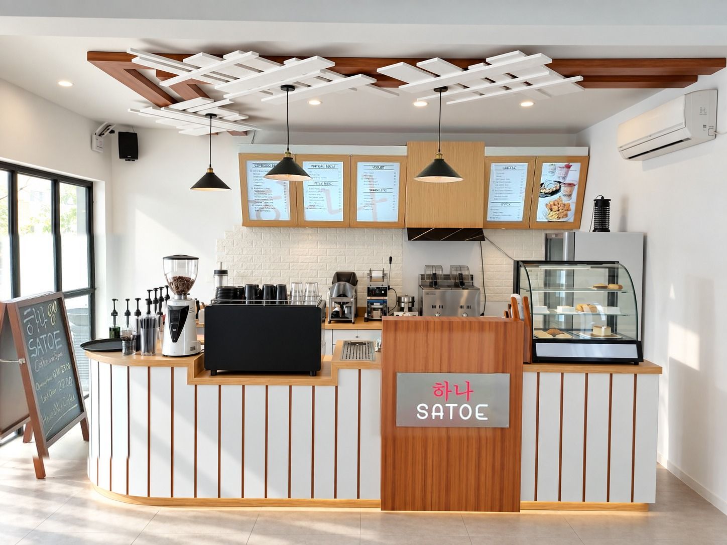 Coffee shop Heritage Cafe dengan counter berbilah putih dan aksen kayu, lemari papan menu, lampu gantung hitam, dan kisi plafon.