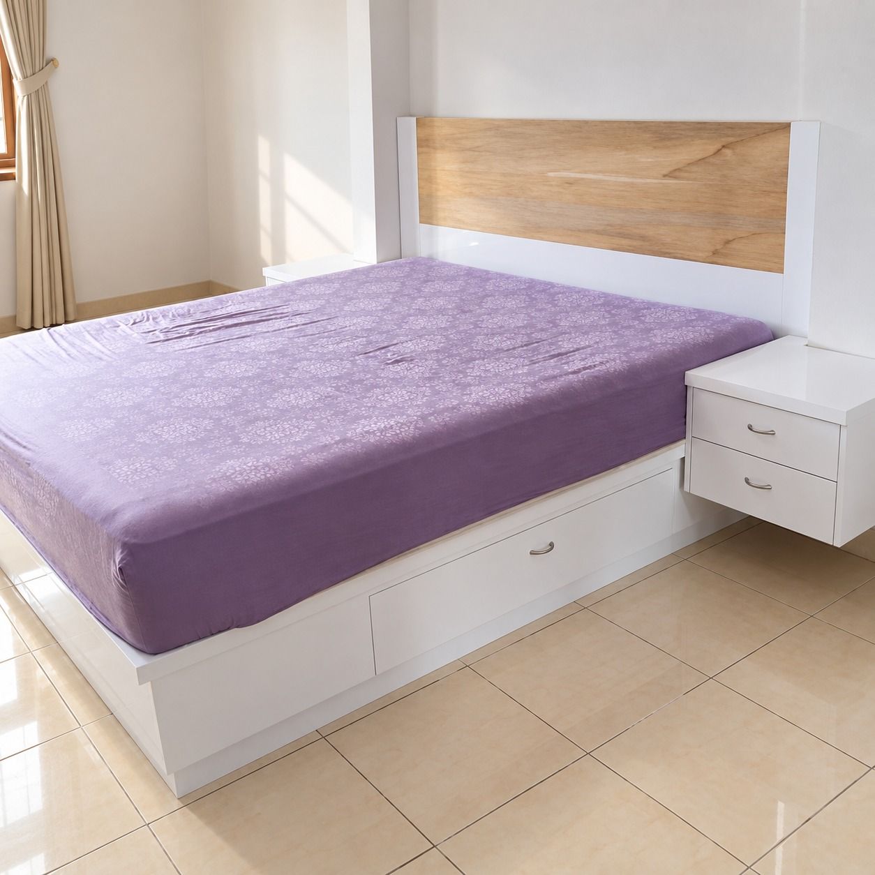Tempat tidur putih dengan laci tarik panjang di sisi, headboard berpanel motif kayu, dan nakas gantung dua laci.