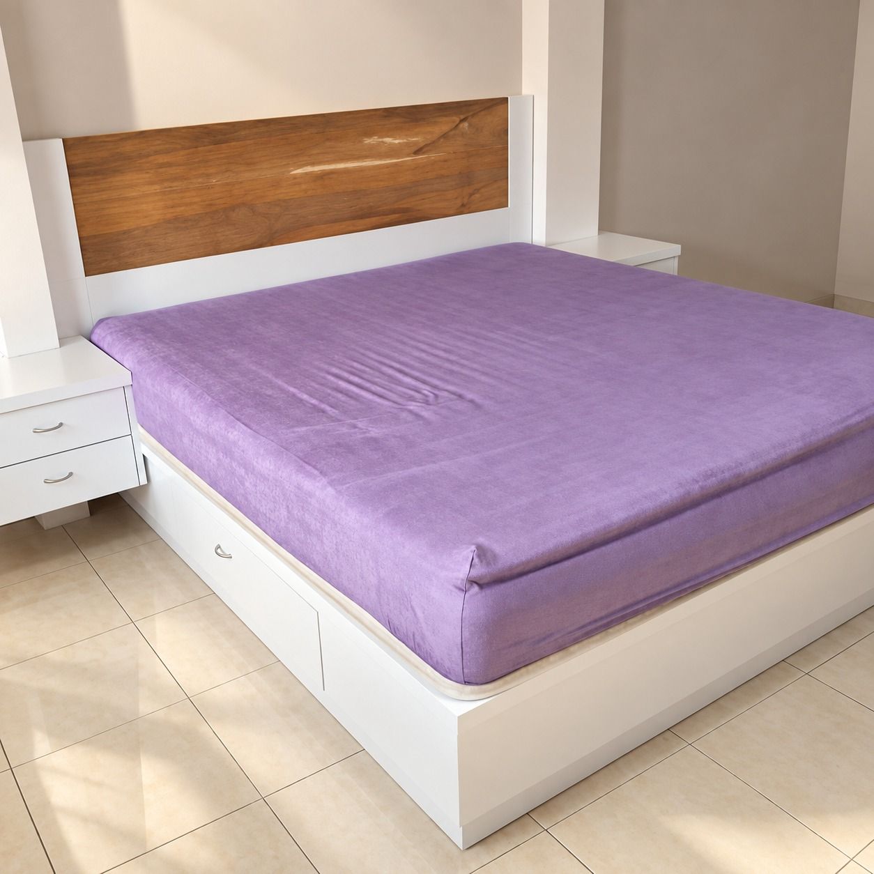 Tempat tidur yang sama dari arah kaki ranjang dengan nakas gantung putih di sisi kiri.